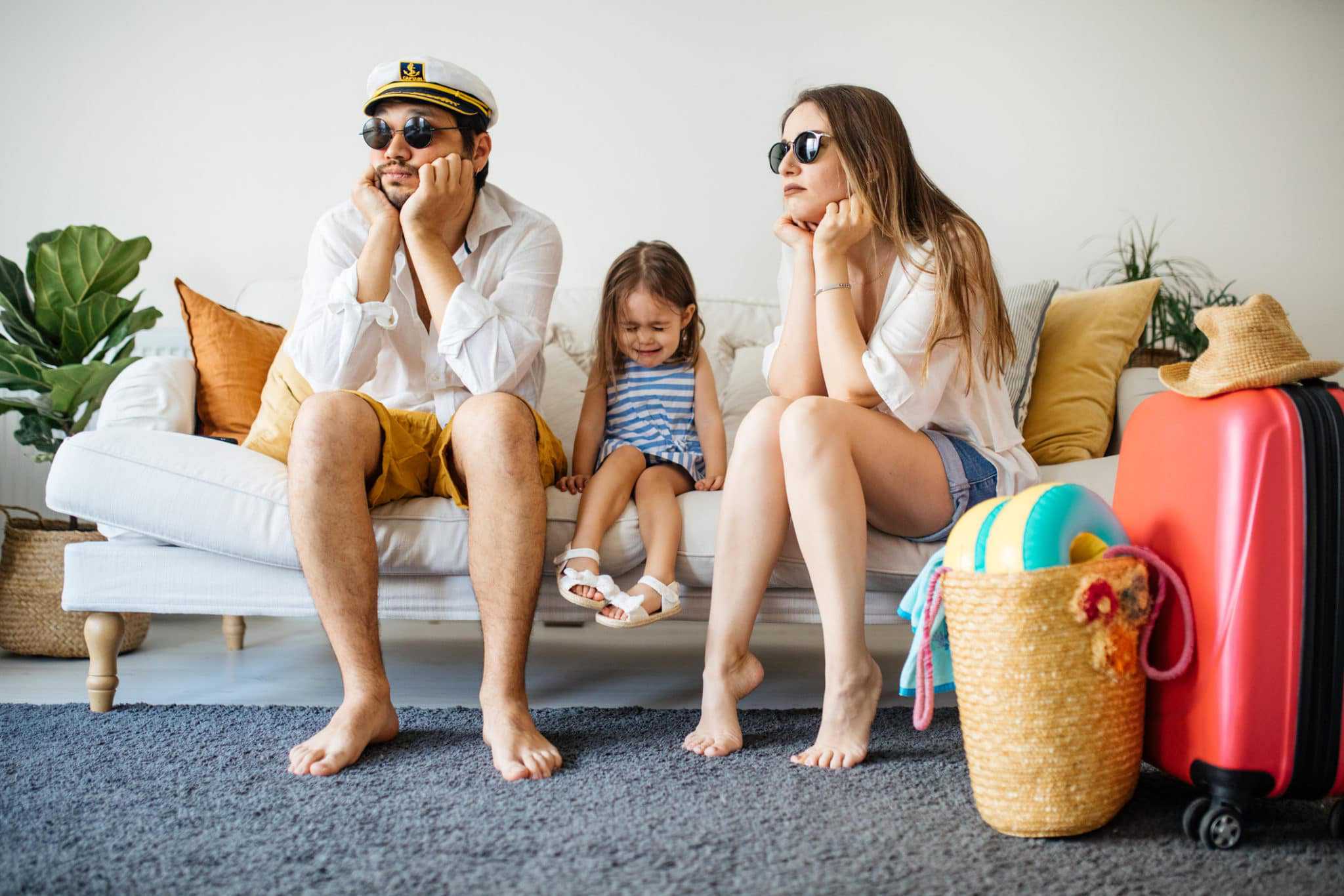 A family from Australia sitting on a couch with suitcases at a Caravan & Camping Expo amidst the pandemic.