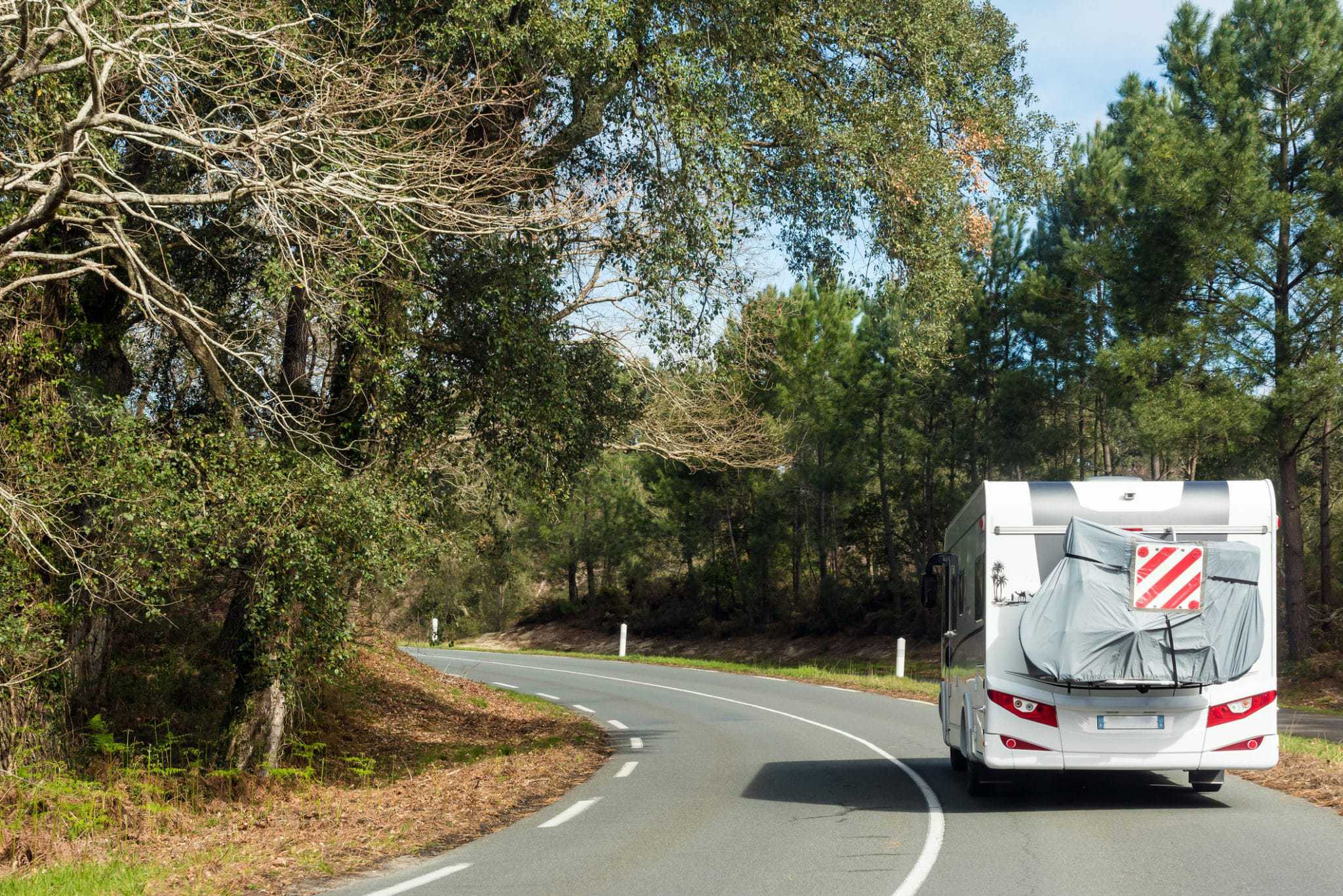 A travelers' rv driving down a country road.