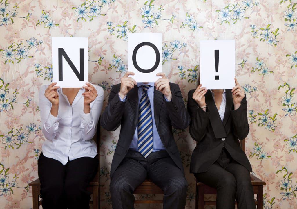 Three business people holding up signs with the word no at Idaho City.