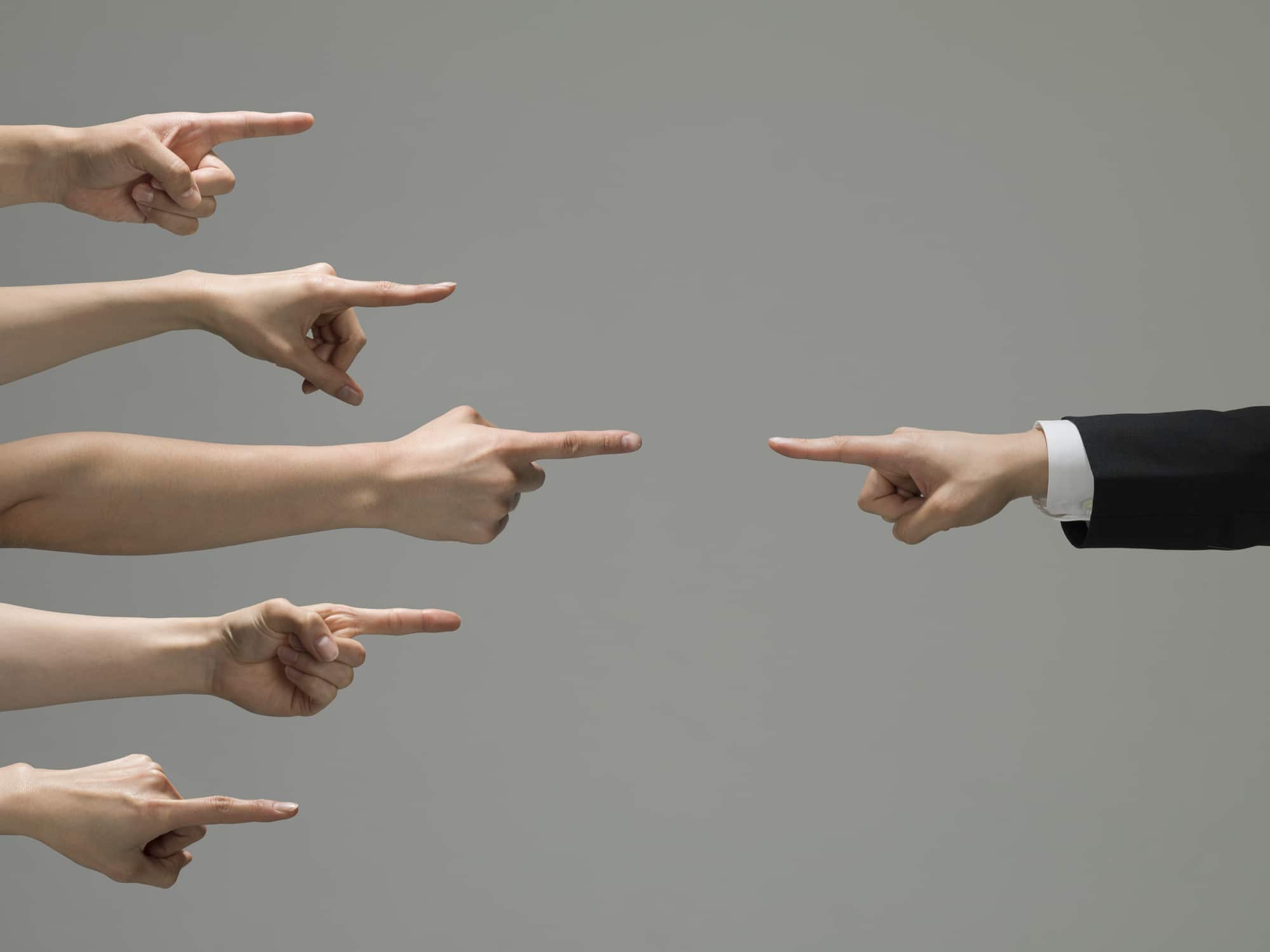 A group of business people pointing at each other during a meeting to discuss the proposed limits.