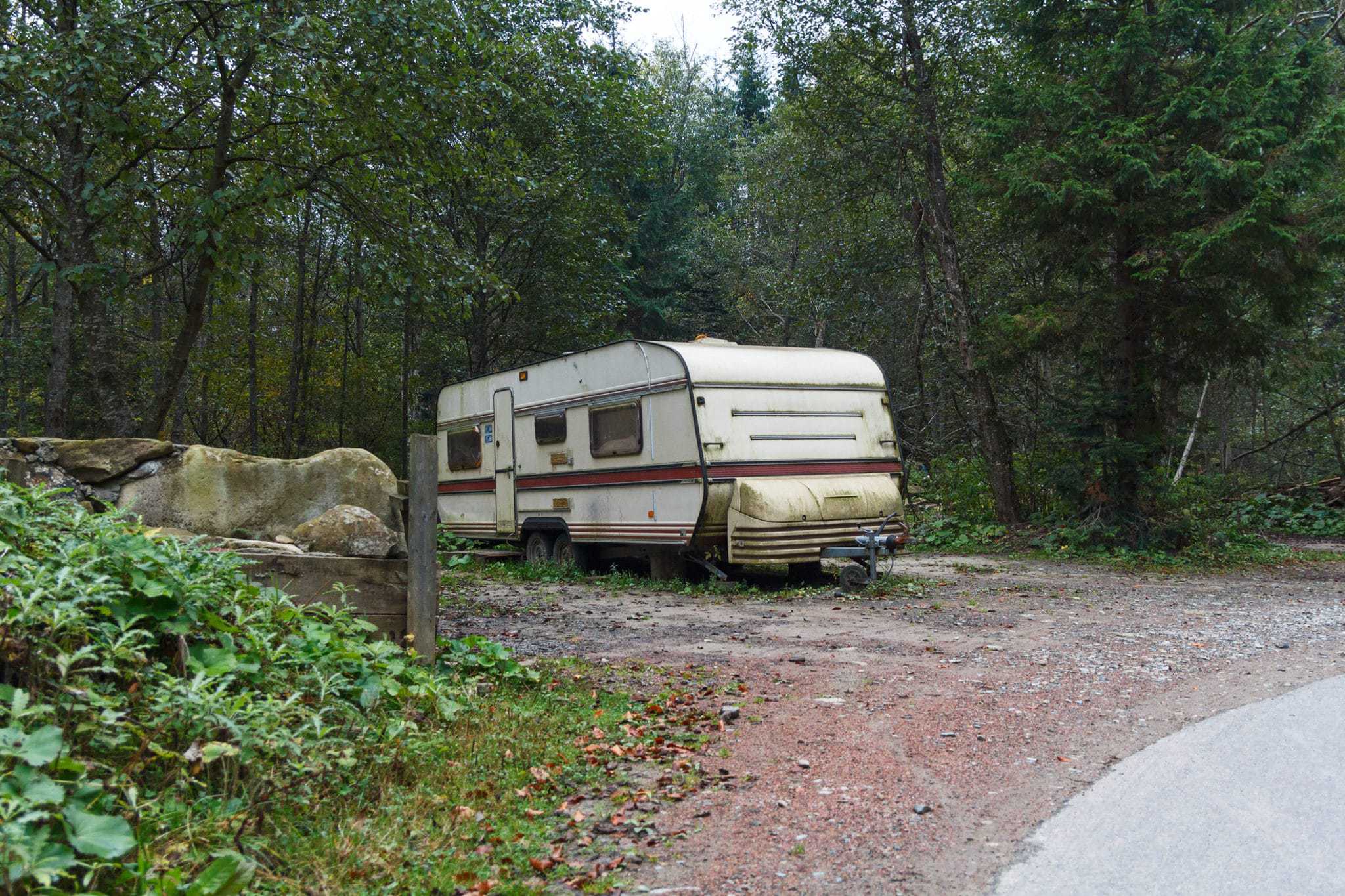 An abandoned RV parked on the side of a road in the woods, in B.C. town.