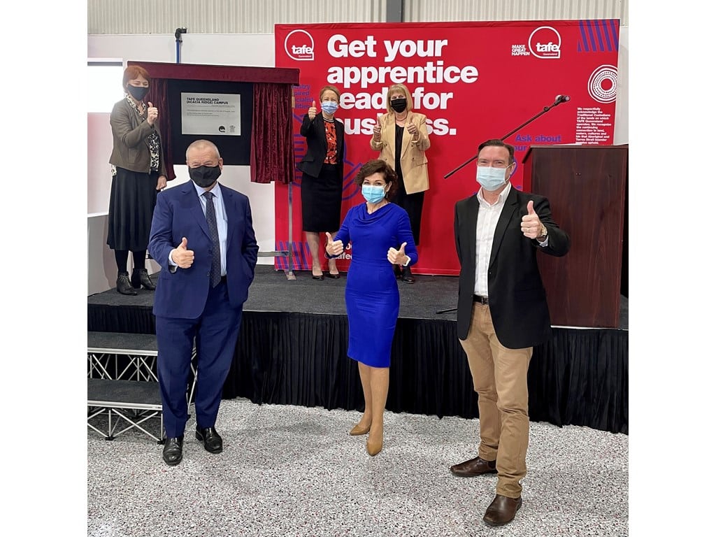 A group of automotive apprentice trainees rev-up their skills on stage, wearing masks.