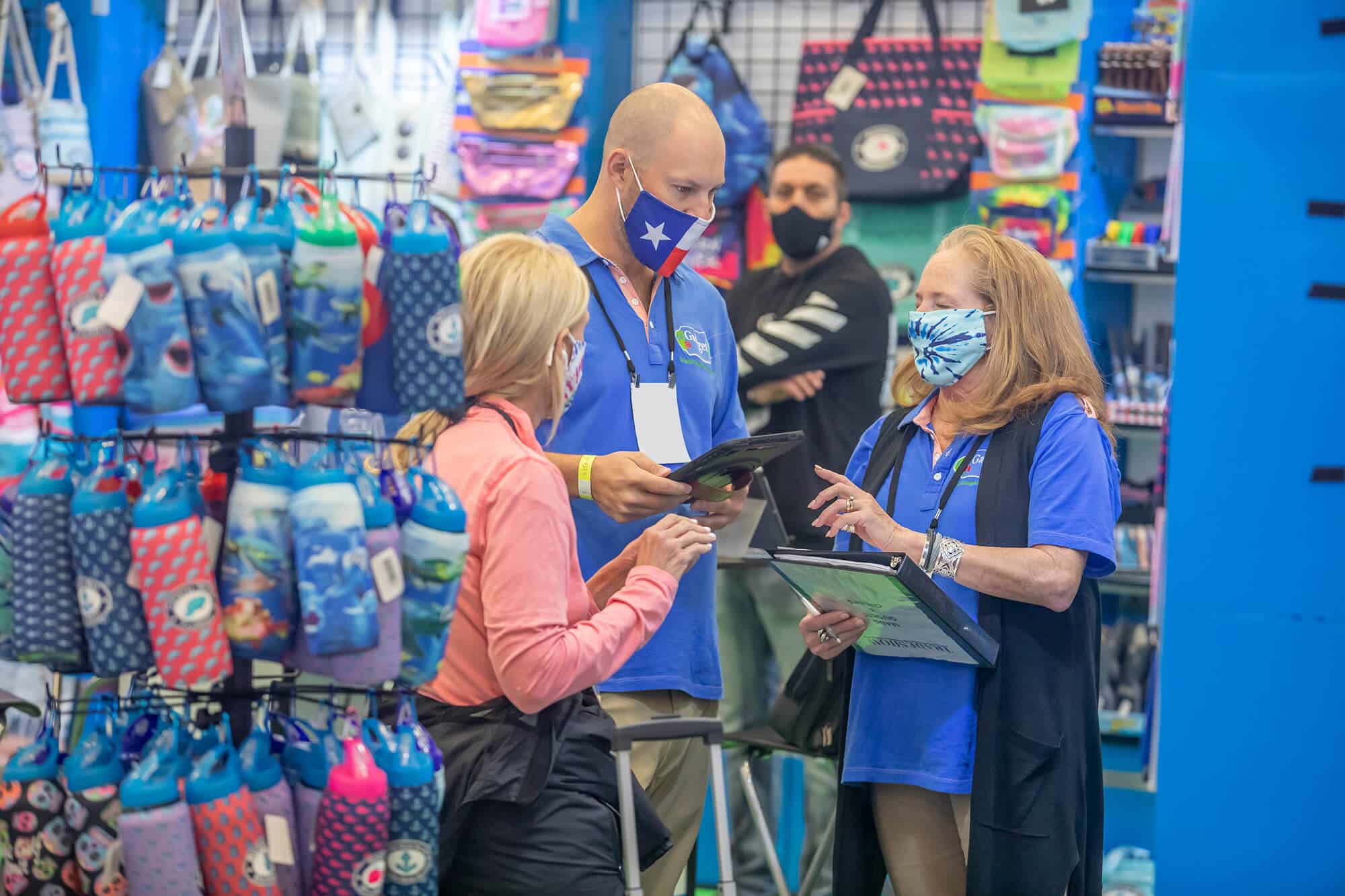 A woman in a blue shirt and a man in a blue shirt are shopping at the International Gift Expo In The Smokies.