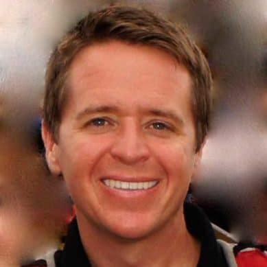 A man in a red shirt smiling for the camera during one of the MC Fireside Chats.