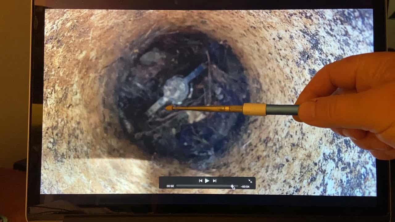 A person is using a tool to open a hole in a computer screen at a campground.