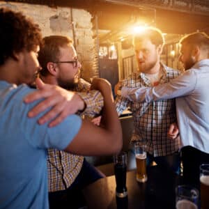 A group of men are drinking beer in a bar.