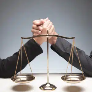 Two business people engaged in a legal fight, holding scales of justice.