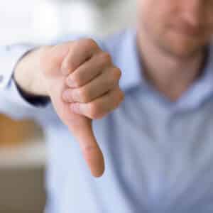 A man is giving a thumbs down sign to express his disapproval.