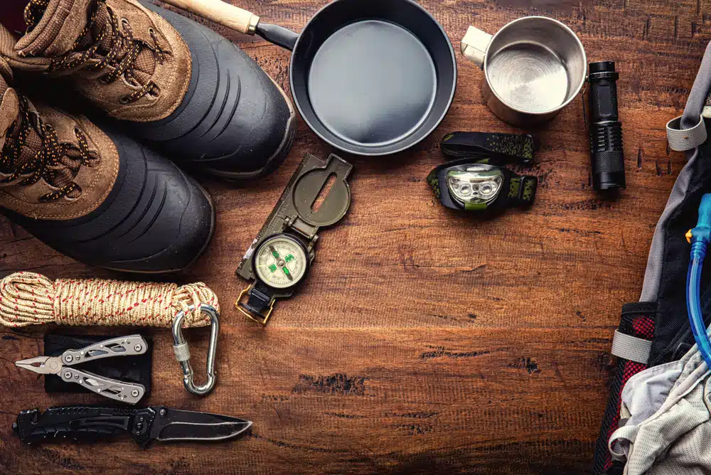 An officially released mobile app displaying a set of hiking gear on a wooden table.