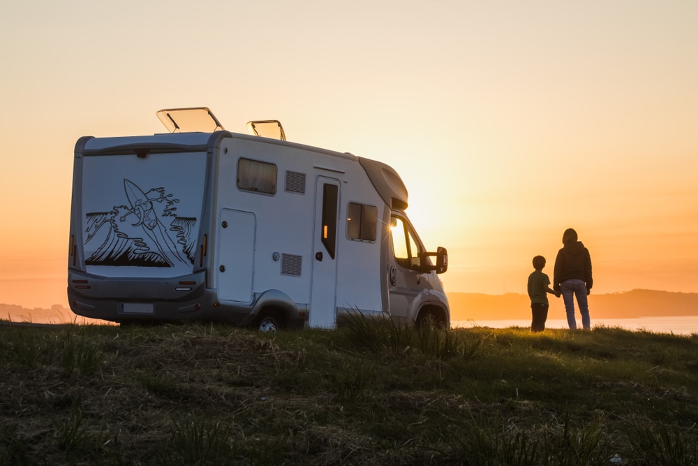 Two people standing next to an RV at sunset in Southeast Michigan.