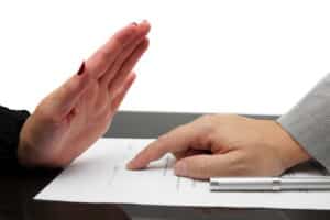 A person signing a document with their hand.