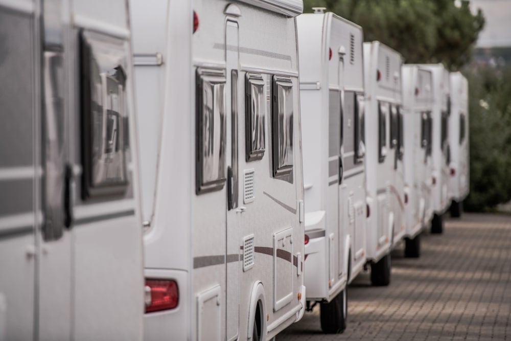 A row of white rvs parked next to each other.