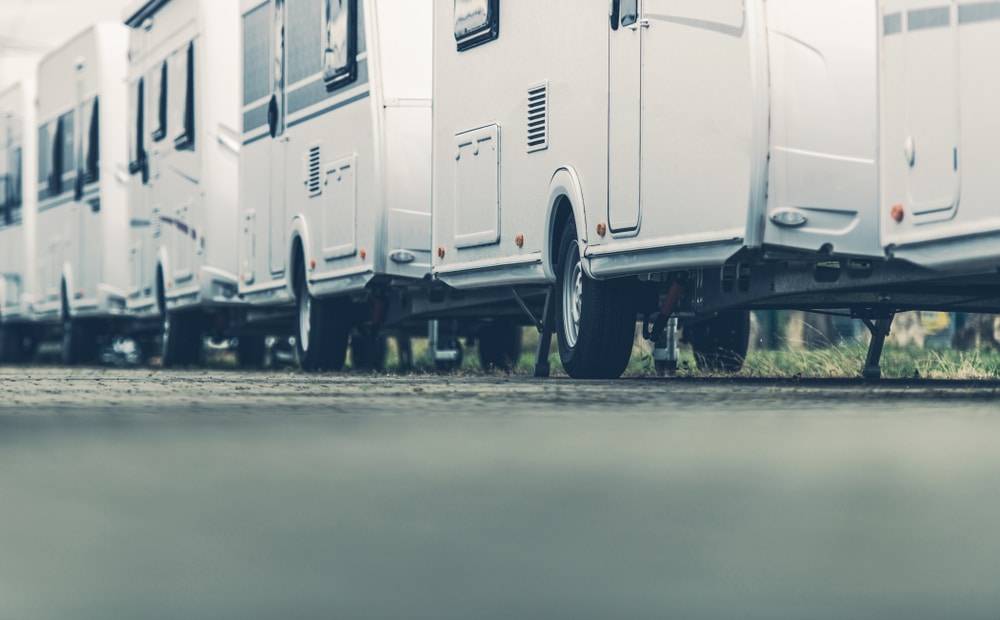 A row of white RVs parked in a parking lot, hosting the Connect Conference.