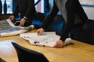 The owner and a group of people standing around a table with paper on it, discussing their big plans for the Missouri Campground.