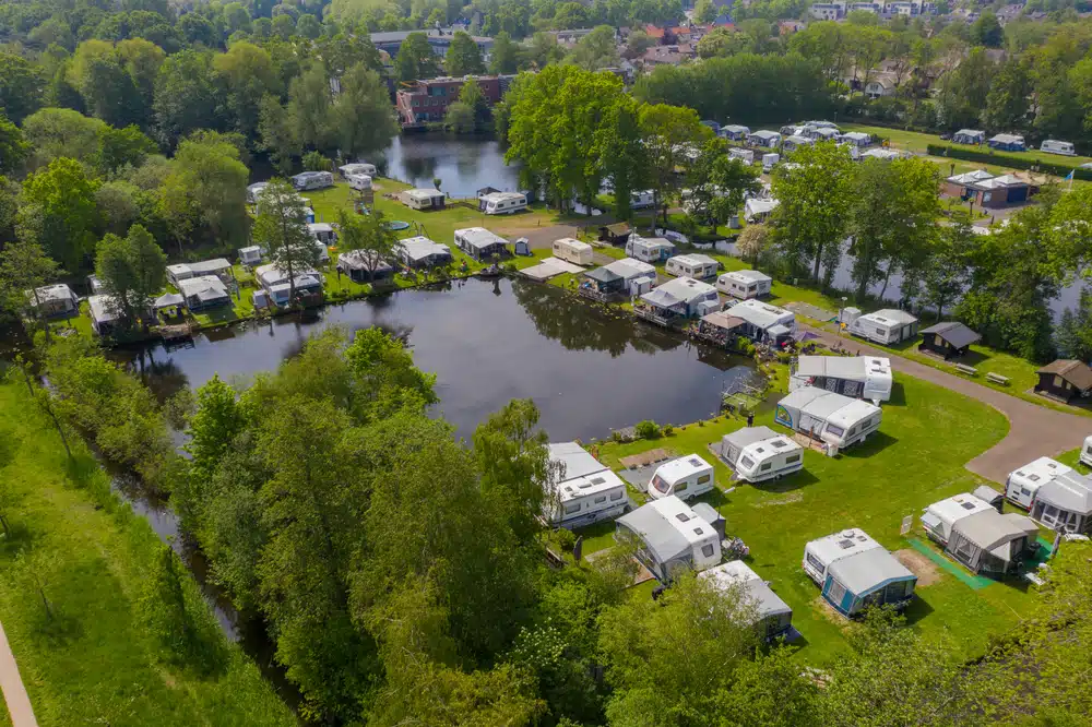 An aerial view of an rv park near a river offering bargain deals for a memorable October staycation.