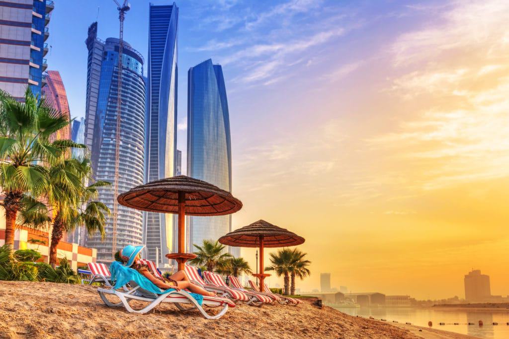Glampers relax on the beach at sunset in Dubai.