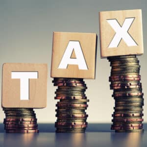 A stack of wooden blocks with the word tax on top.