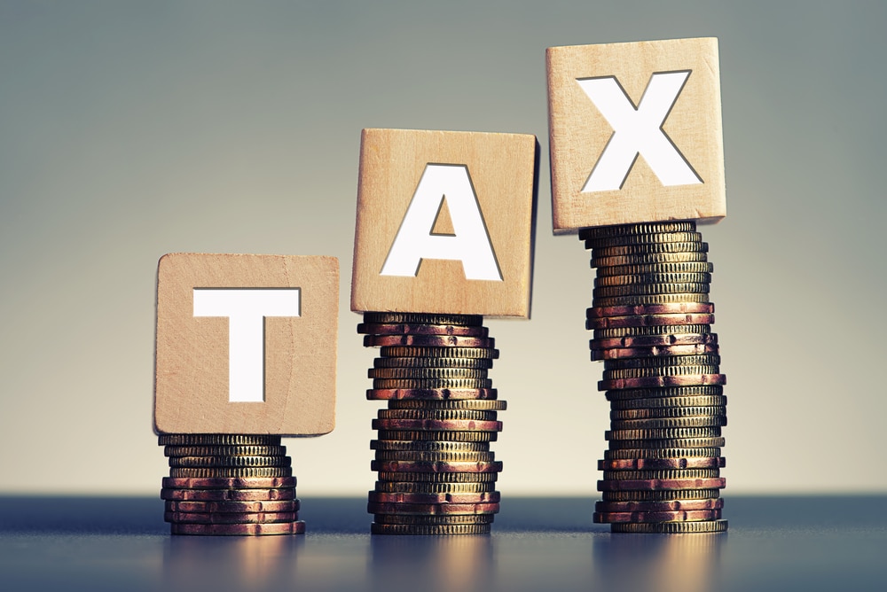 A stack of wooden blocks with the word tax on top.