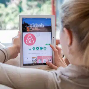 A woman in New York using an iPad with the Airbnb app on it.