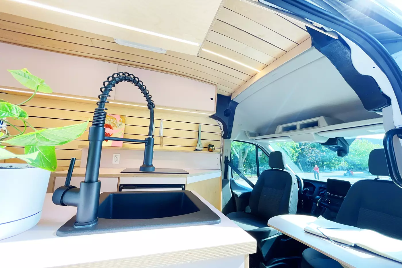 The interior of an off-grid camper van with a sink for a couple.