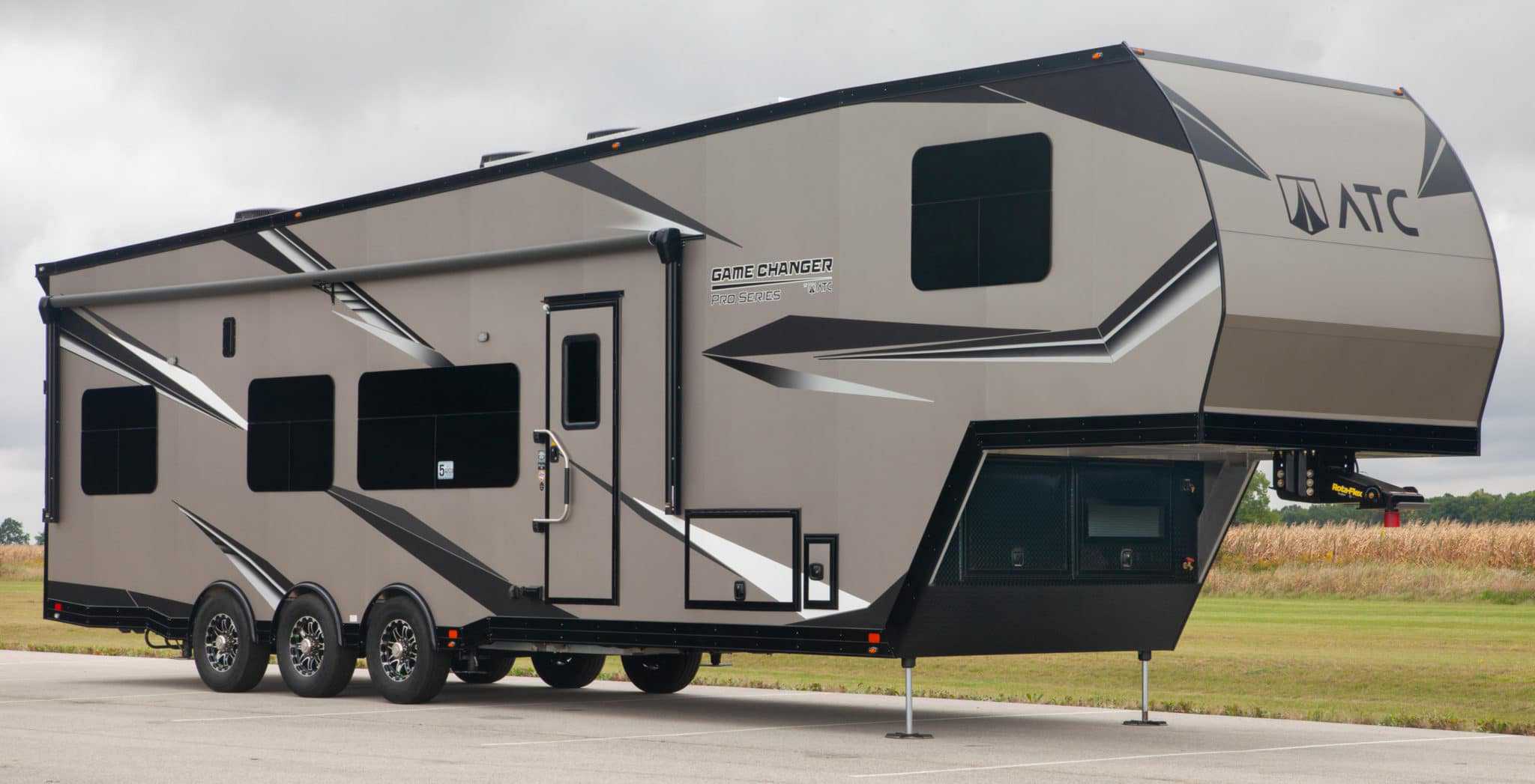 A black and gray RV parked in a parking lot.