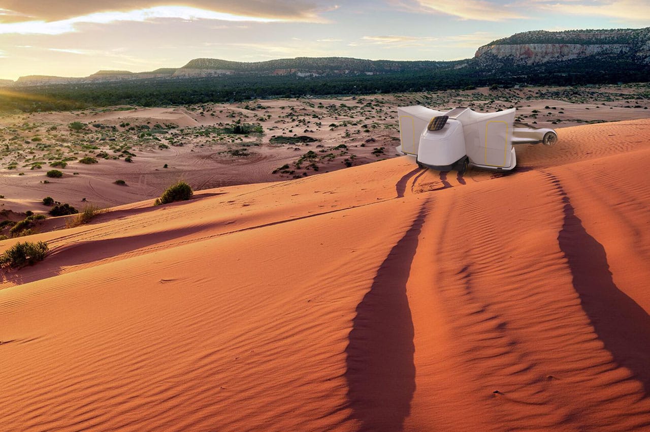 A sustainable white chair sits on top of a red sand dune.