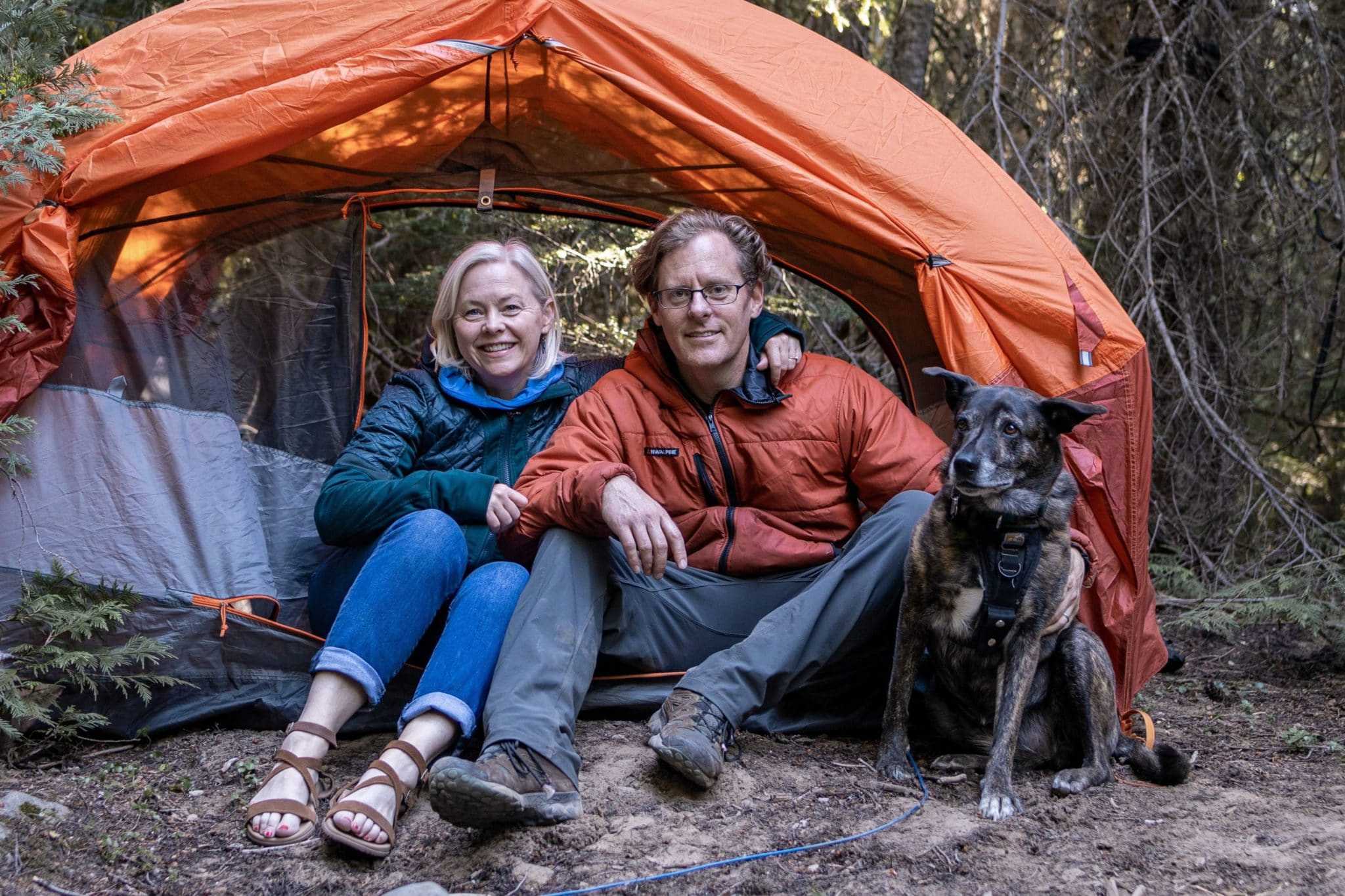 A man and woman, accompanied by their beloved dog, enjoy the outdoors while using The Dyrt camping app.