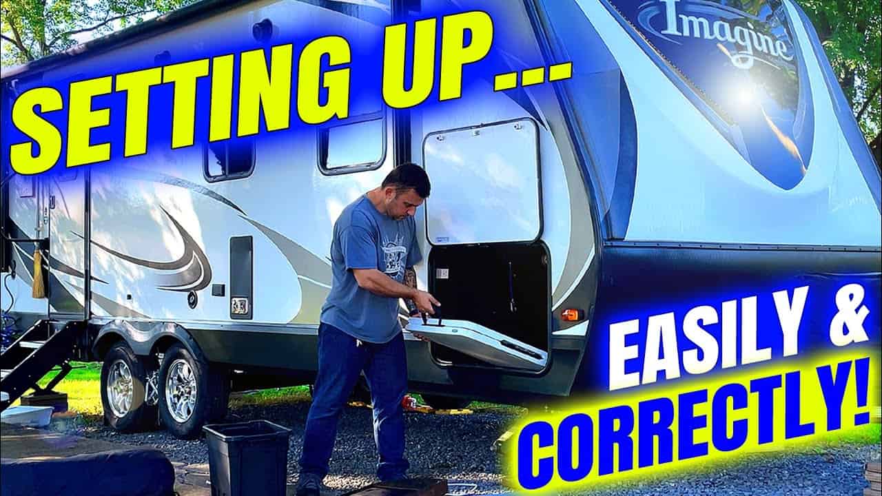 A man is setting up his campsite with his travel trailer, ensuring that he sets up everything correctly.