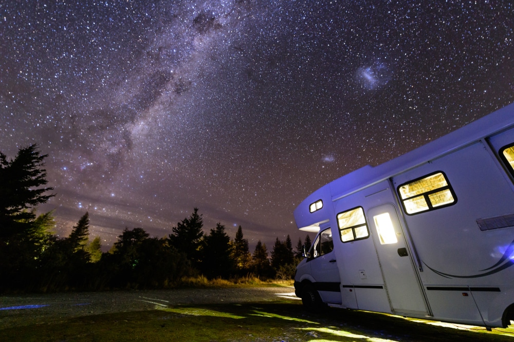 An rv parked under a starry sky, perfect for regional tourism and investment.