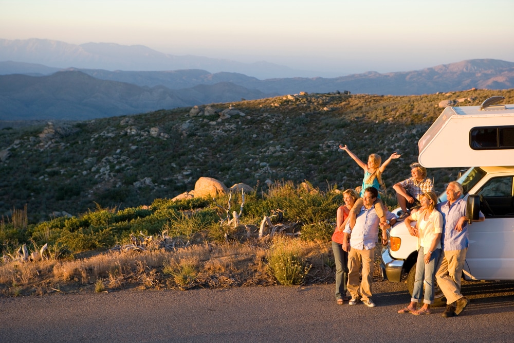 Fun Town RV stands proudly in front of an RV with majestic mountains forming a breathtaking backdrop.