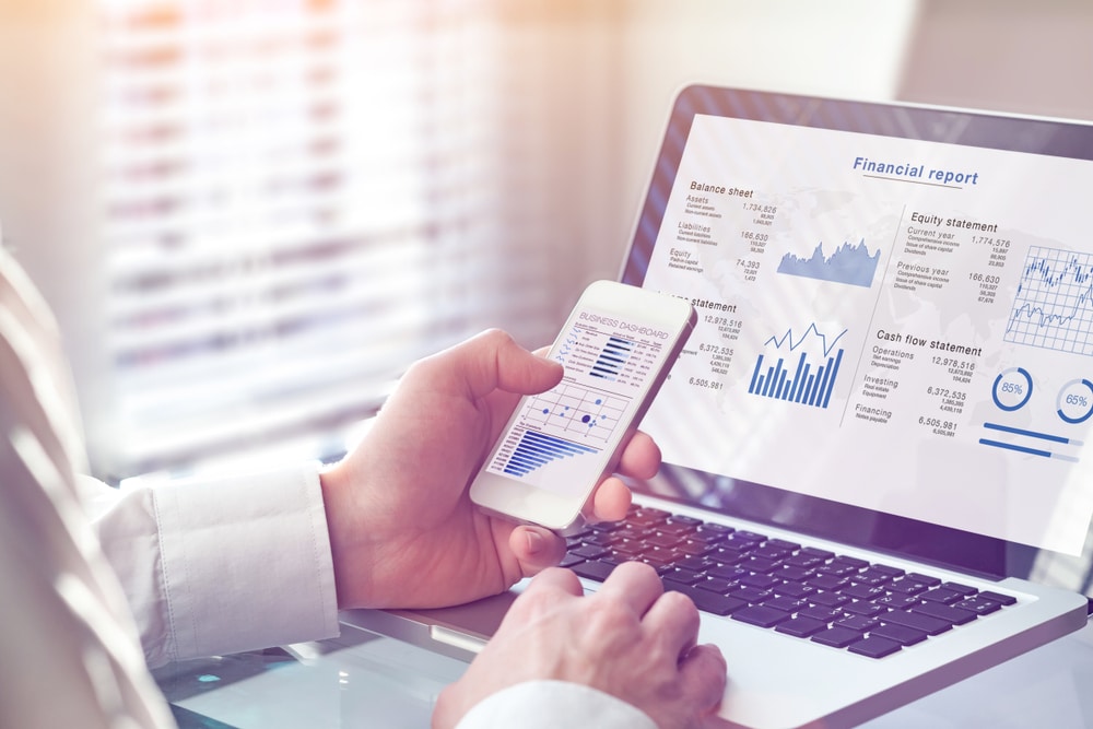 A person using a laptop analyzing graphs depicting Winnebago Industries' full year fiscal 2021 performance in the fourth quarter.