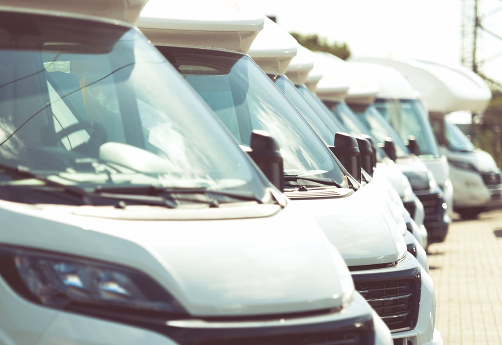 A row of white RVs parked next to each other at Aloha RV Acquisition, a leading RV retailer known for its extensive stores network.