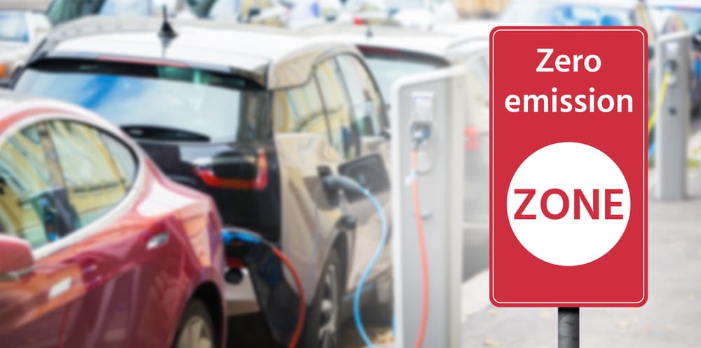 A parked car displaying a zero emission zone sign.