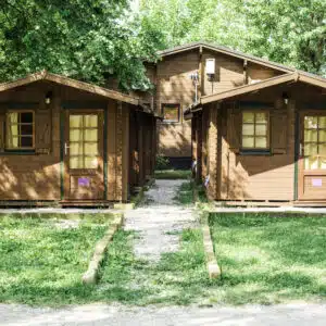 Two wooden cabins in a wooded area.