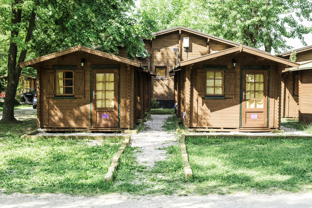 Two wooden cabins in a wooded area.