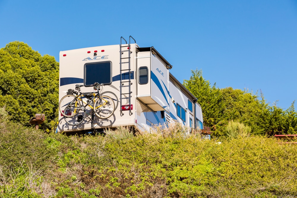 An RV parked on the side of a hill.