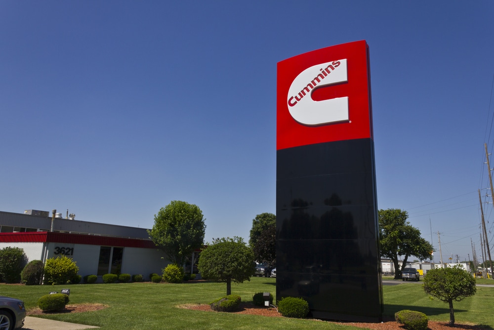 A red and black sign in front of a building, indicating collaboration between Autonomous Vehicle System Providers and Cummins.