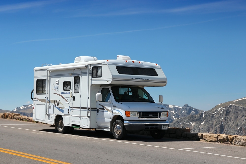 A Winnebago RV, recipient of the RVDA DSI Quality Circle Award, parked on the side of a scenic mountain road.