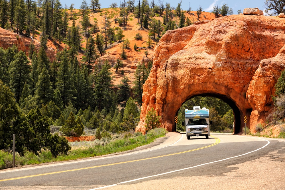 A Thetford truck, ready to ship, driving down a road through a tunnel.