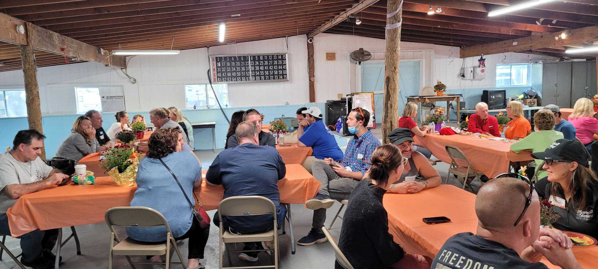 A successful group sitting at tables in a barn, holding a meeting organized by NJCOA.