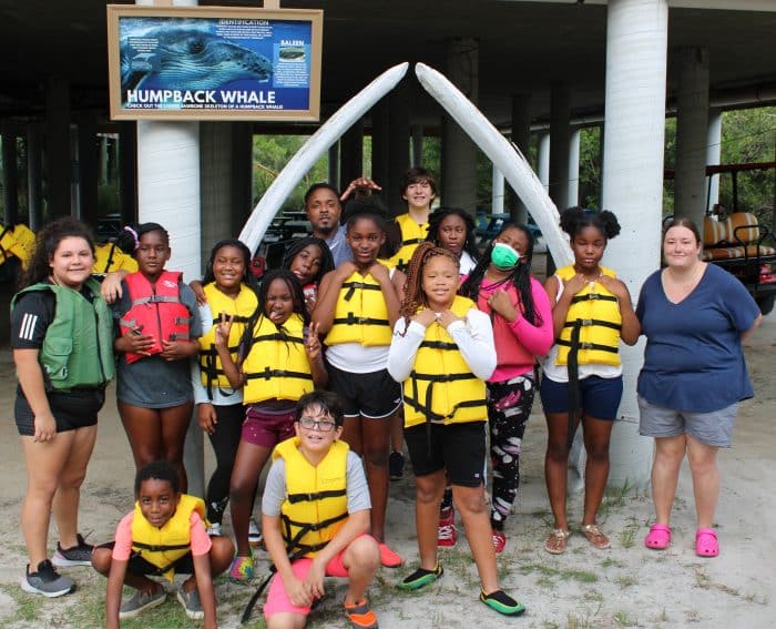 Enrollees in life jackets posing for a picture during a Youth Guidance experience.