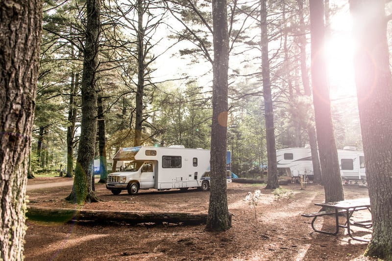 A group of rv's parked in a wooded area, perfect for Dyrt campers seeking tranquil Commission-Free Bookings in enchanting Campgrounds.