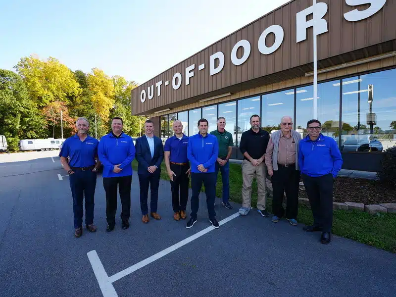 Out-of-Doors Mart, an RV retailer, acquires a group of people standing in front of an out-of-doors store.