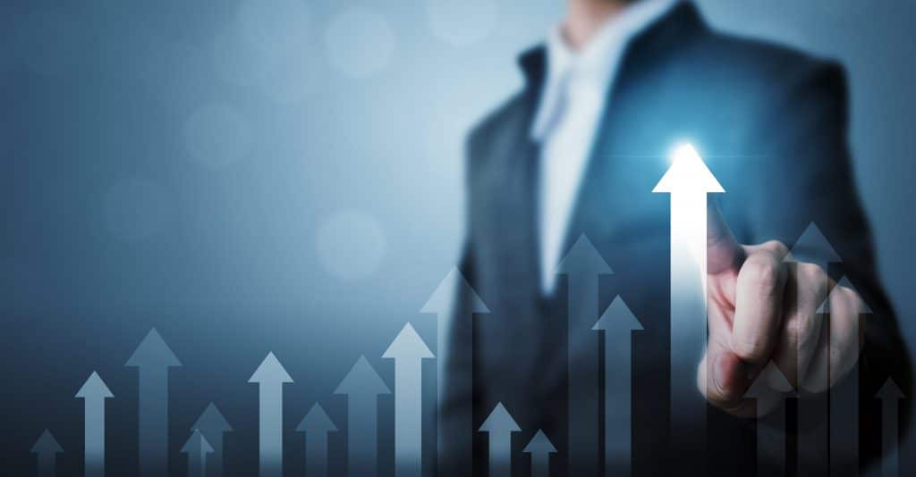 A businessman is pointing at an upward arrow in the Global Camping and Caravanning Market.