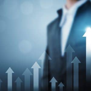 A businessman is pointing at an upward arrow in the Global Camping and Caravanning Market.