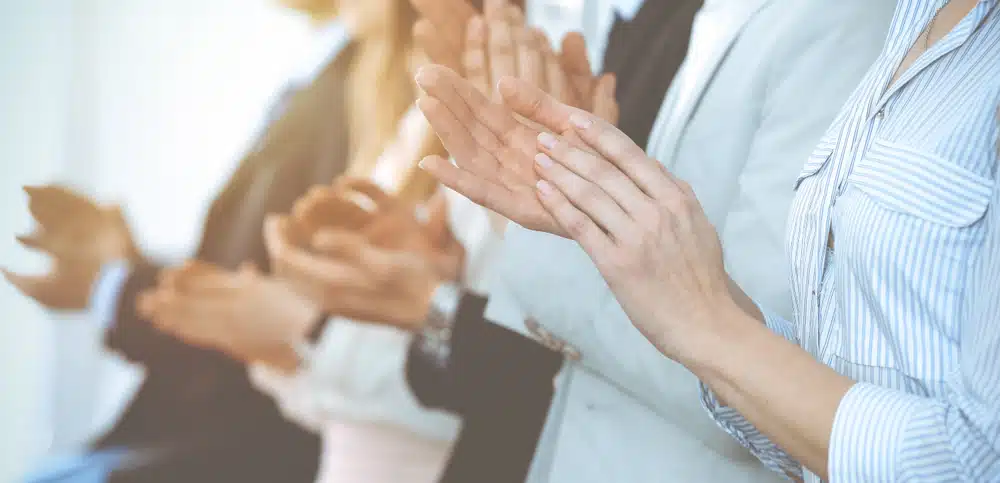 A group of business people clapping their hands.