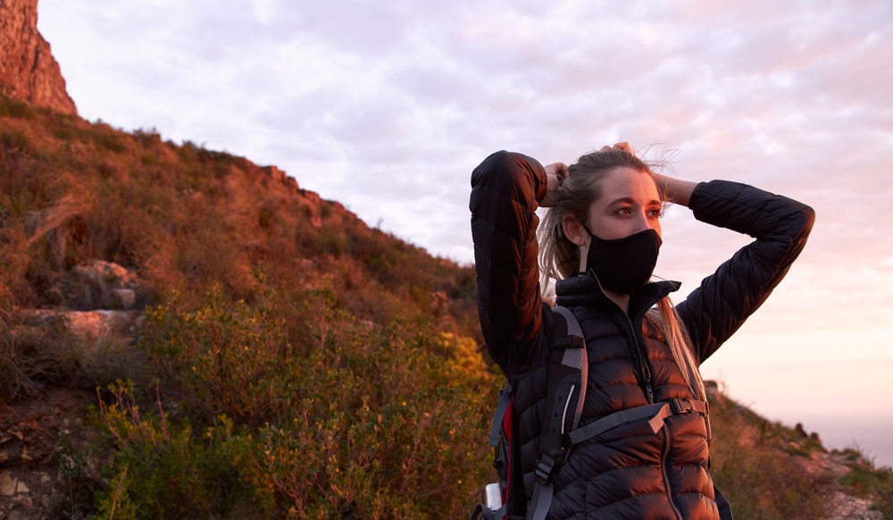 A woman wearing a face mask on a mountain during the Covid-19 pandemic.