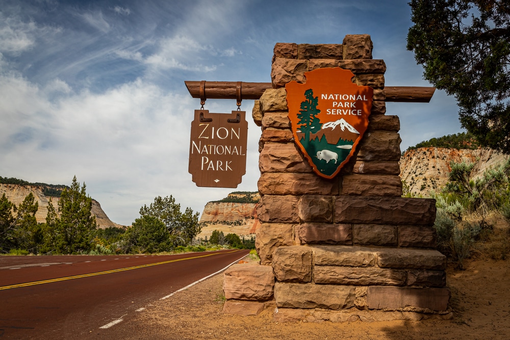 A sign at the entrance to Zion National Park welcoming visitors and highlighting new initiatives to increase access and enhance visitor experience.