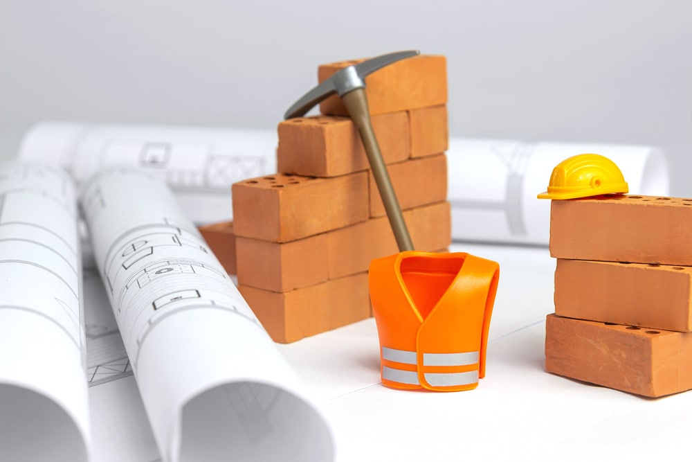 A set of construction tools and bricks on a white background.