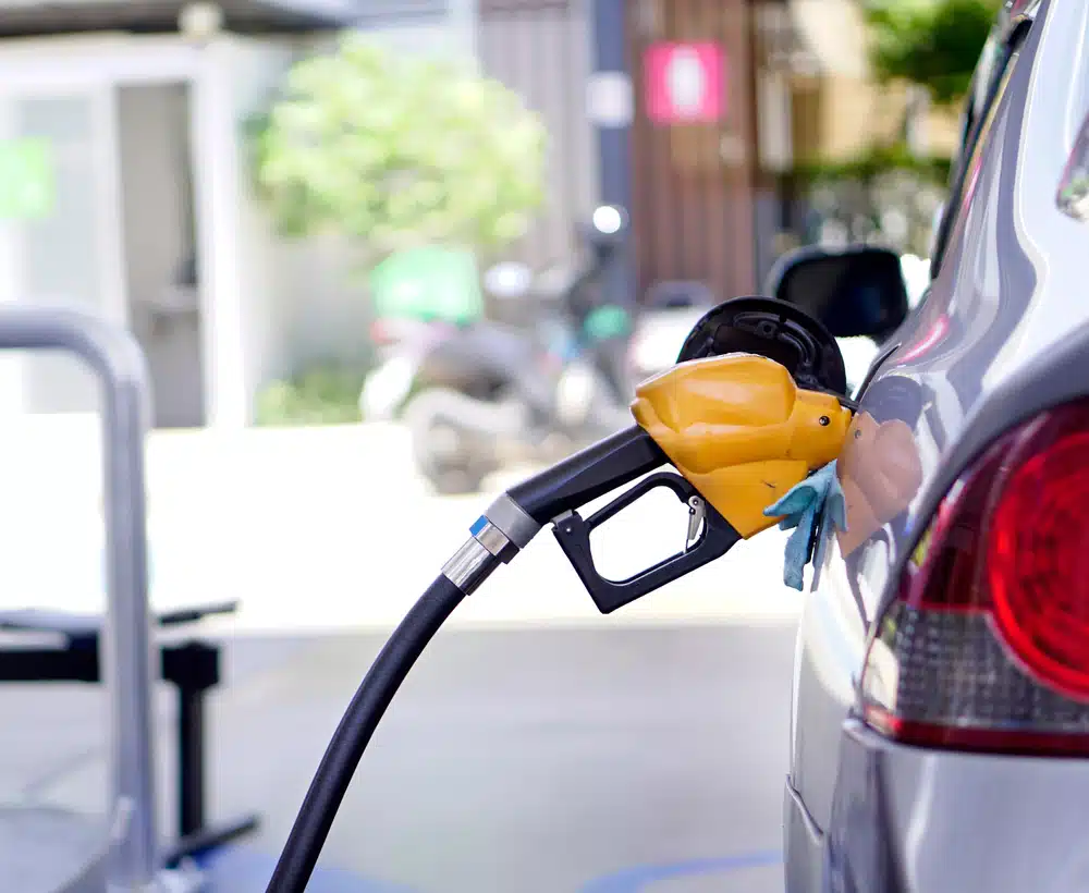 A car is getting relief at the pump as it fills up with gas at a gas station.